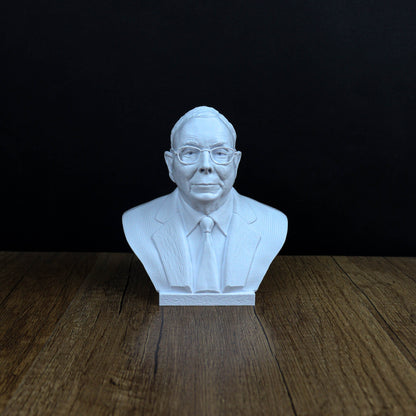 A white bust of a man wearing a suit and tie, sitting on a wooden surface against a black background.